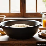 Home 23 제과제빵 전문가 되는 법 - A cozy, rustic kitchen scene featuring a baker’s workspace with essential tools: a large mixing bowl...